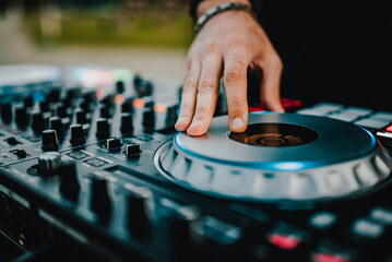 Fototapeta na wymiar DJ Hands creating and regulating music on dj console mixer in concert outdoor