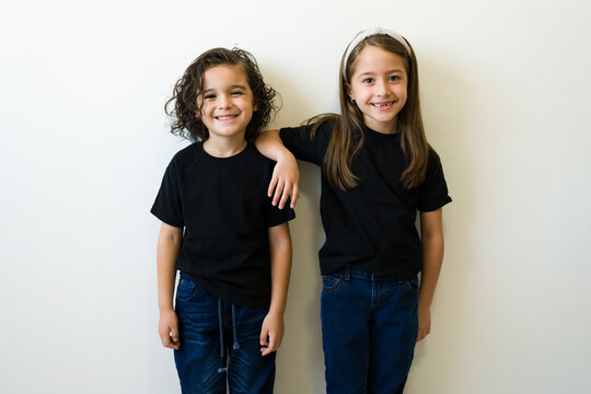 Cheerful kids posing with their design prints mockup t-shirts