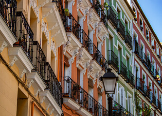 Fototapeta na wymiar Exterior view of beautiful historical buildings in Madrid, Spain, Europe. Colorful Mediterranean urban street in the former Jewish quarter, Lavapiés, Embajadores neighborhood of the Spanish capital.
