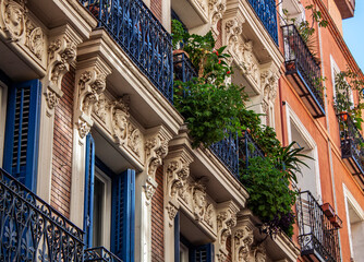 Exterior view of beautiful historical buildings in Madrid, Spain, Europe. Colorful Mediterranean urban street in the former Jewish quarter, Lavapiés, Embajadores neighborhood of the Spanish capital.