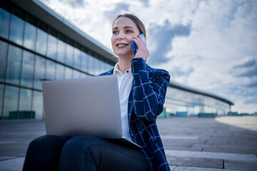 Businesswoman speaking on smartphone on street