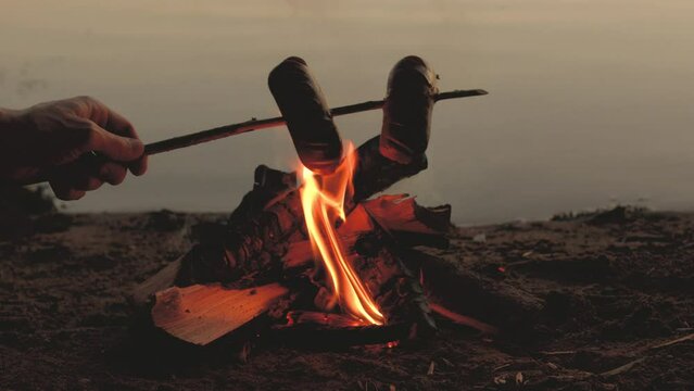 Marshmallow is roasted on a fire in nature. the concept of outdoor recreation, camping. Close-up fire, slow motion.
