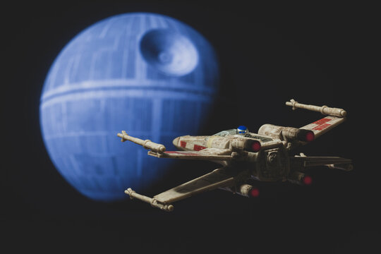 NEW YORK USA - AUG 28 2022: recreation of a scene from Star Wars A New Hope with a Rebel X Wing fighter approaching the Death Star - Disney Micro Galaxy Squadron vehicle