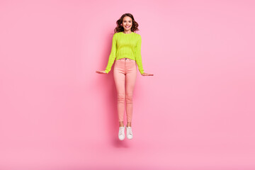 Full size photo of optimistic young lady jump wear green shirt trousers boots isolated on pink color background