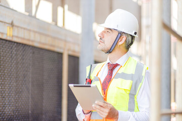 Close up hand industrial industrial plant with a tablet in hand, Engineer looking of working at industrial machinery setup in factory.