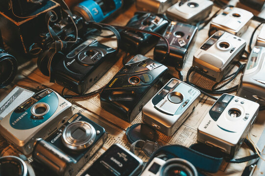 Berlin, Germany - August 14, 2022: Vintage cameras at the flea market. Old and used digital and film cameras for hipster photography. Lifestyle, retro concept.