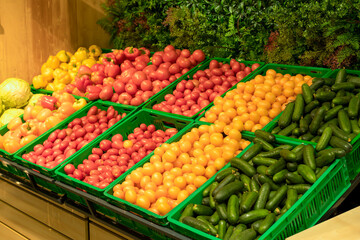 Supermarket vegetables background. Fresh tomatoes and peppers in boxes on the supermarket counter. Food, grocery, agriculture concept