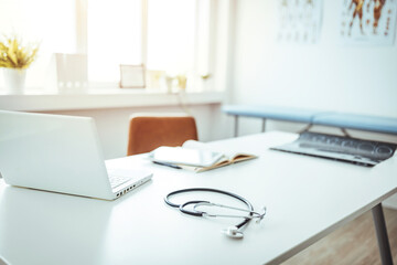 Empty Doctor's Office With Examination Table And Doctor's Desk. Stethoscope, prescription medical...