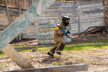 a teenager with a machine gun and a paintball mask plays war