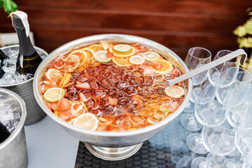 large bowl of lemonade with ice and sliced fruit