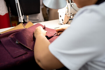 Women's hands sew pieces of fabric on a sewing machine close-up. horizontal frame