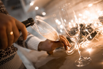 People clinking glasses of champagne against blurred background, closeup. Bokeh effect
