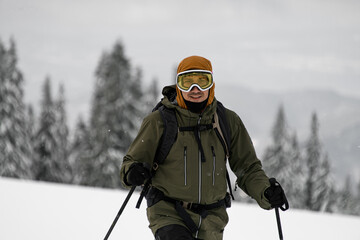 front view of male skier in ski mask on his head on blurred background