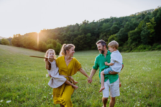 Happy young family spending time together outside in green nature.
