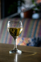 a glass of white wine on a wooden table
