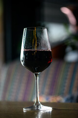 a glass of red wine on a wooden table
