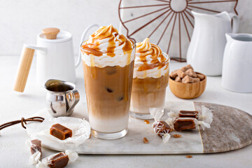 Iced caramel latte topped with whipped cream and caramel sauce - obrazy, fototapety, plakaty