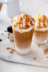 Iced caramel latte topped with whipped cream and caramel sauce
