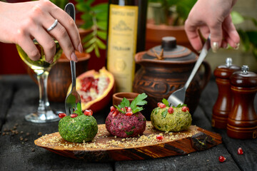Georgian snack in the form of balls on a wooden board on the table, macro photo
