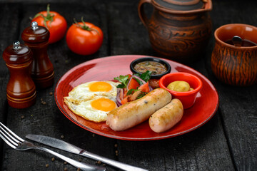 breakfast fried egg with sausage and vegetables in a red plate
