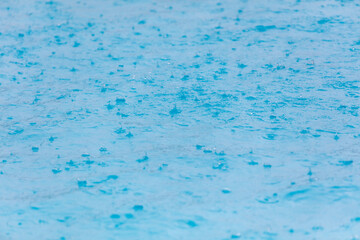 Surface of blue water in heavy rain.