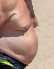 Naklejka premium Fat man on the shore by the sea.