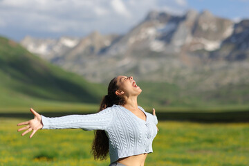 Excited casual woman screaming in the mountain