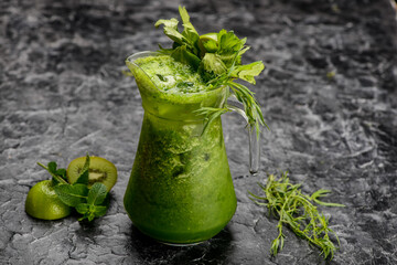 kiwi basil lemonade in a jug on the table with greens and kiwi
