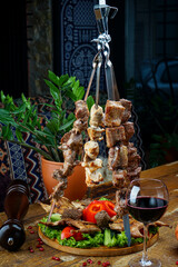 Georgian kebab on skewers on the table with wine, vertical photo
