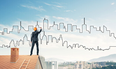 Man architect draw silhouette of modern city on blue sky. Mixed