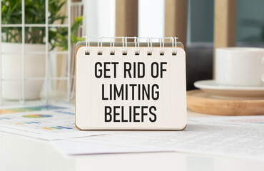 Get Rid Of Limiting Beliefs. text on wood table, on white paper