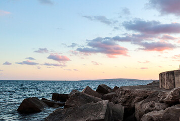 Fototapeta na wymiar sunset with rain clouds on the rocky promenade of the west dyke in mallorca