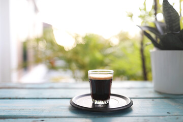 Coffee glass cup on blue wooden table in the morning