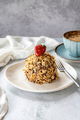 Hazelnut, strawberry and chocolate cake on gray background. Fruit and cream cake covered with chocolate on the outside. close up