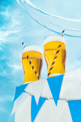 Glasses of cold frothy light beer over summer blue sky background. Vacation, happiness, Oktoberfest...