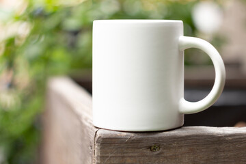 White mug in the garden. - 525344433