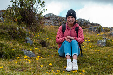 Atractiva mujer sentada en el césped después de una caminata y disfrutando de la hermosa...