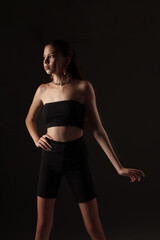 Fototapeta premium Portrait of a young girl on a dark background. Beauty, clean skin, stylish earrings