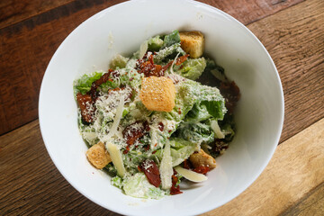 Caesar salad with grilled bacon on white bowl 