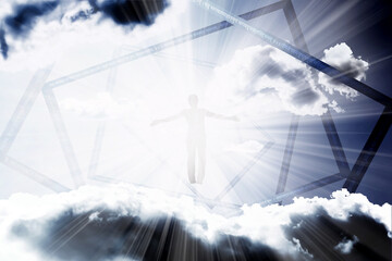 A silhouette of a man flies into a portal in the sky with clouds in the rays of bright light. The concept of freedom of choice, open mind, meditation.