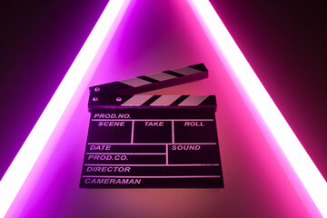 Clapperboard movie slate on Glowing neon lighting background. video director making cinema film....