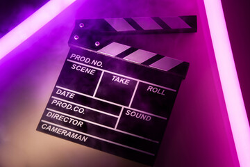 Clapperboard movie slate on Glowing neon lighting background. video director making cinema film....