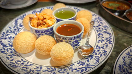 Pani Puri, Golgappe, Indian Food Snacks from the plate. Indian evening street food. Pani Puri or Puchka Water Balls