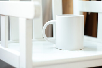 A white mug on a white chair - 525352237