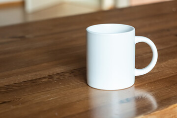 White mug on the wooden table. - 525352238
