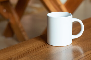 White mug on the wooden table. - 525352239