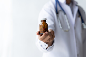 doctor's hand holding a bottle of medicine isolate on white background.