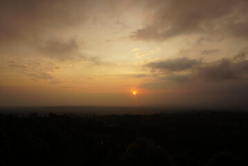 Sunrise over the hill. There are some clouds