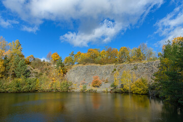 flooded quarry surrounded by trees in autumn