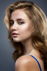Naklejka premium Sensual portrait of a beautiful teenager girl. Grey background. Vertical.